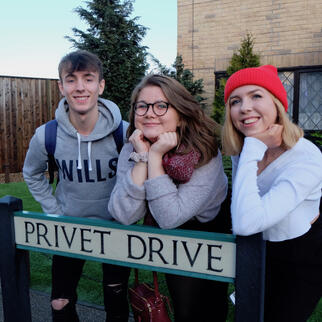 society members posing with privet drive road sign